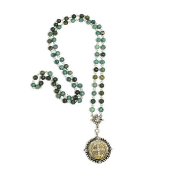 Turquoise beaded rosary necklace with silver medallion pendant.
