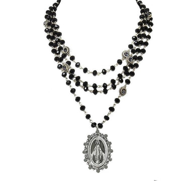 Layered black glass bead necklace with a silver Virgin Mary pendant.
