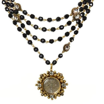 Black glass bead necklace with gold accents and a detailed antique coin pendant.
