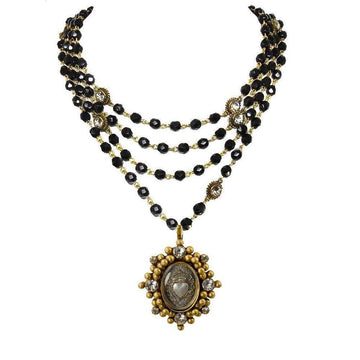 Layered black beaded necklace with gold accents and a detailed heart pendant.
