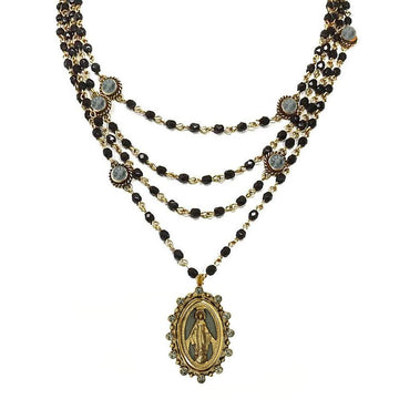 Multi-strand necklace featuring black beads, gold accents, and a Madonna medallion.
