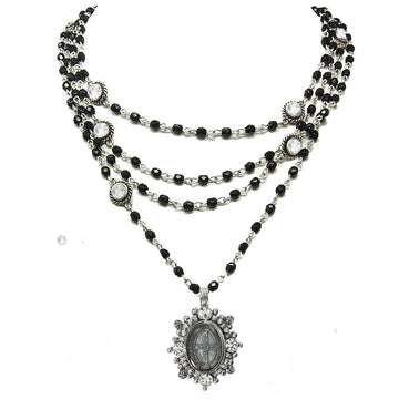 Layered black and silver beaded necklace with a clear crystal and antique medallion pendant.

