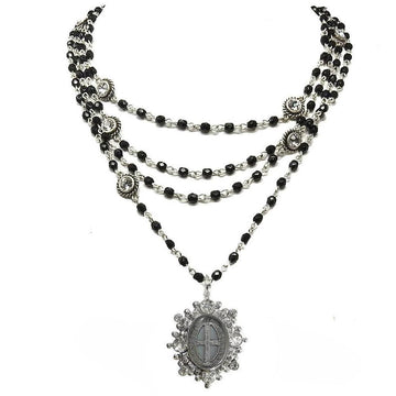 Layered black bead necklace with silver accents and a detailed medallion pendant.
