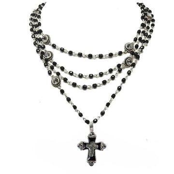 Layered black bead necklace with silver accents and cross pendant.
