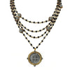 Magdalena in Jet necklace: multi-strand black bead & gold chain design, featuring a St. Christopher medal pendant.
