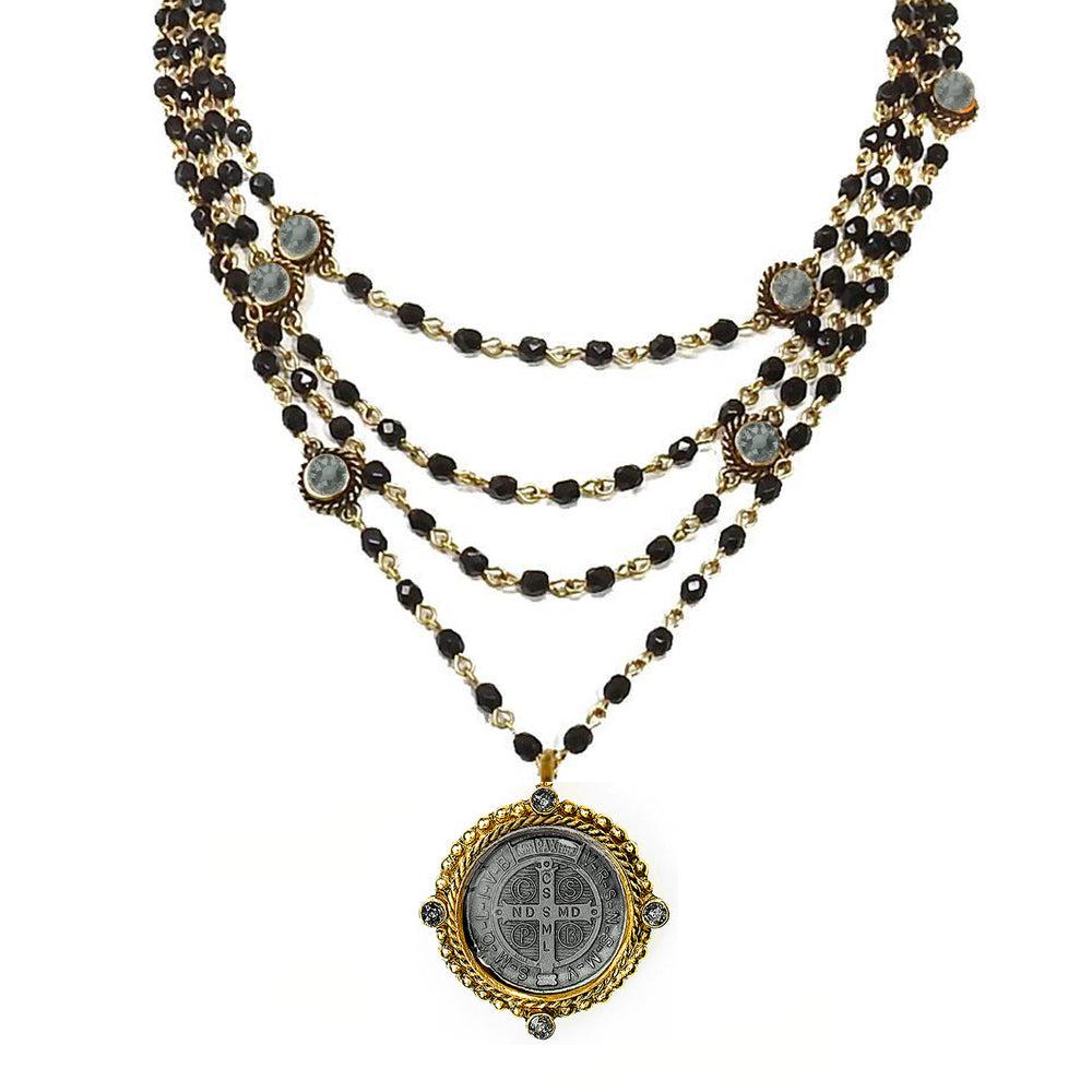 Magdalena in Jet necklace: multi-strand black bead & gold chain design, featuring a St. Christopher medal pendant.
