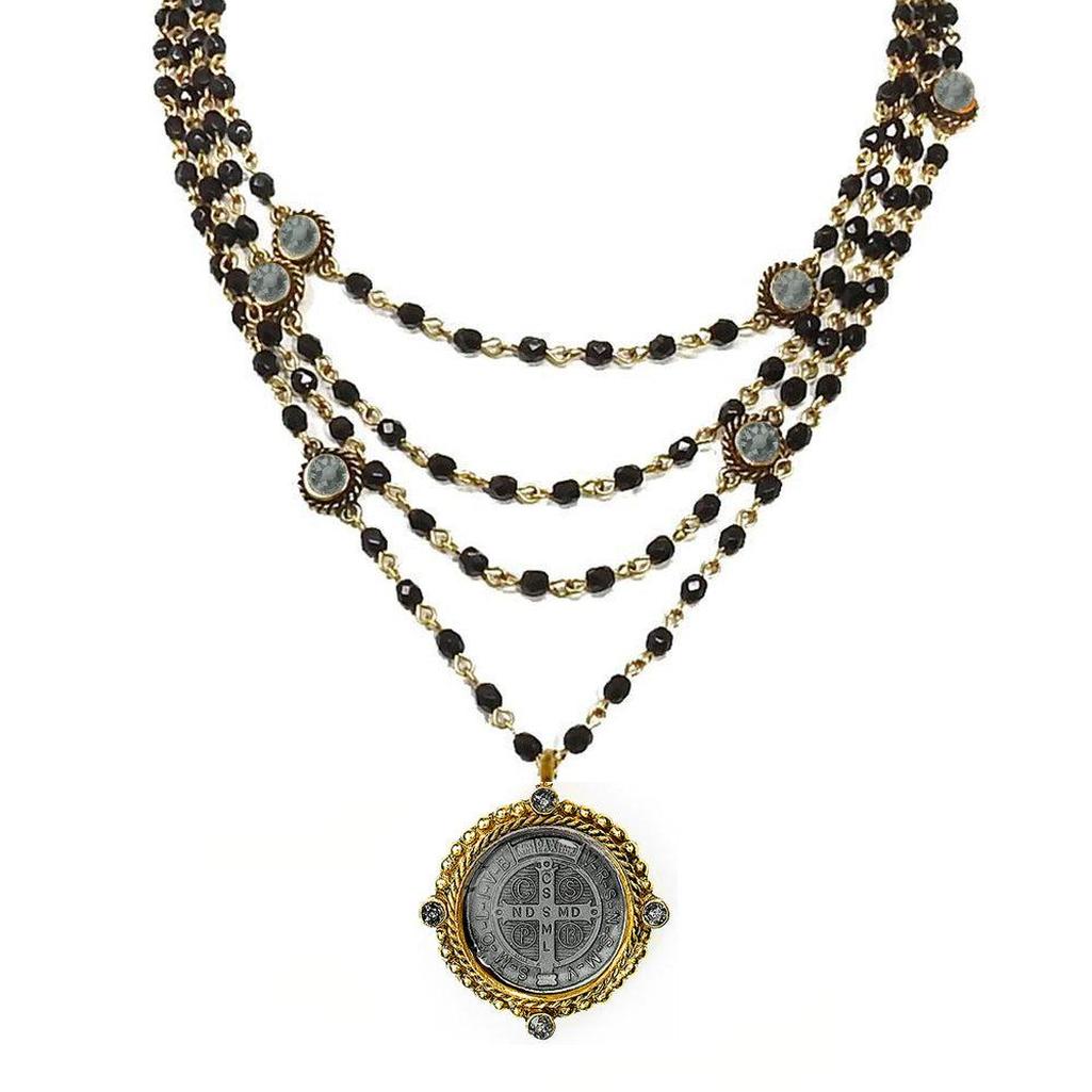Magdalena in Jet necklace: multi-strand black bead & gold chain design, featuring a St. Christopher medal pendant.
