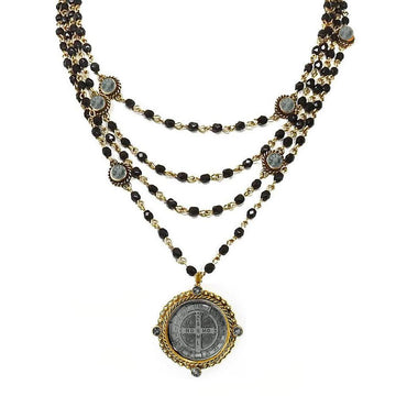Magdalena in Jet necklace: multi-strand black bead & gold chain design, featuring a St. Christopher medal pendant.
