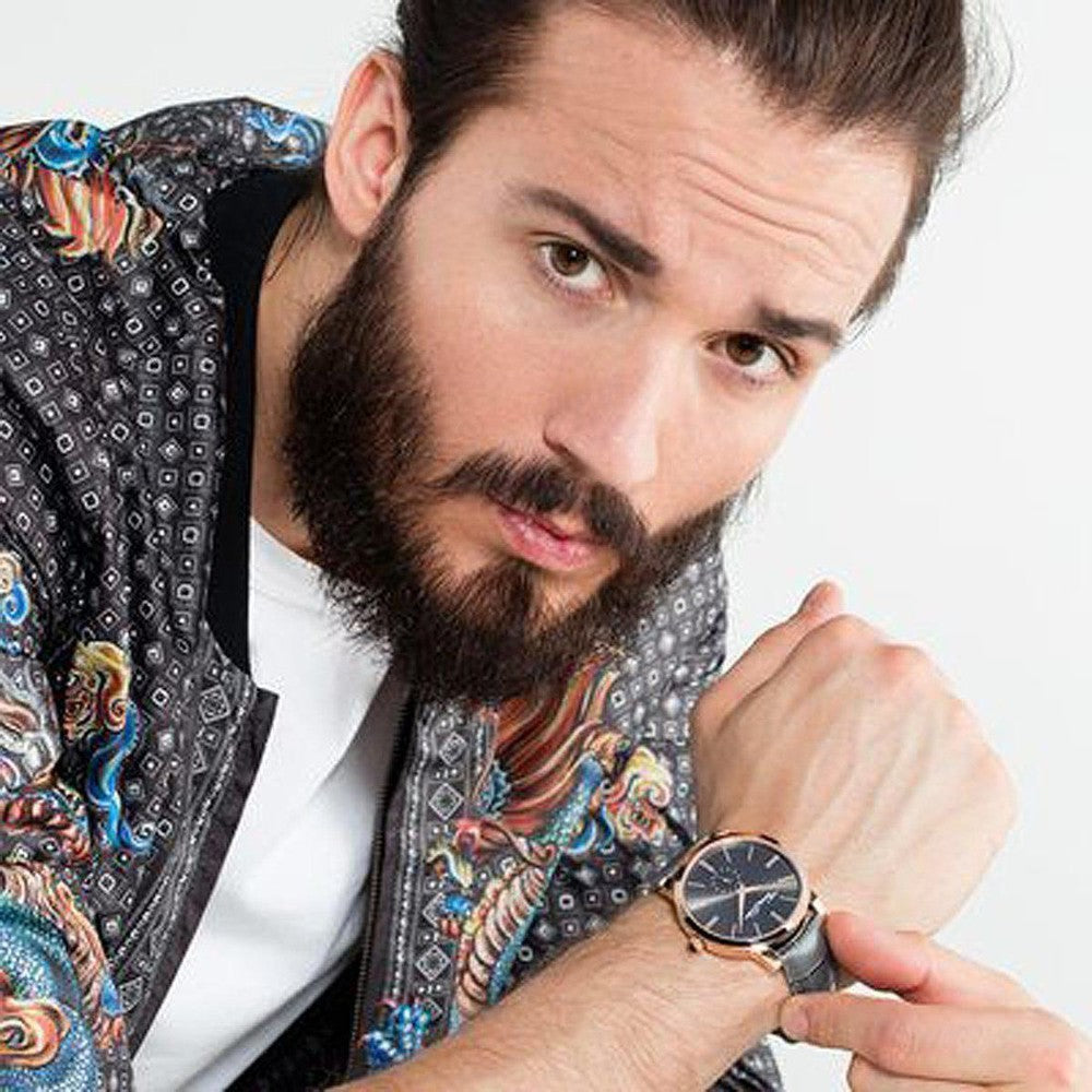 Man's grey leather wristwatch with dark face, shown on model's wrist.

