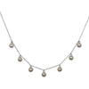 Mini Crystals silver necklace with delicate chain and seven small, ornate pendants.
