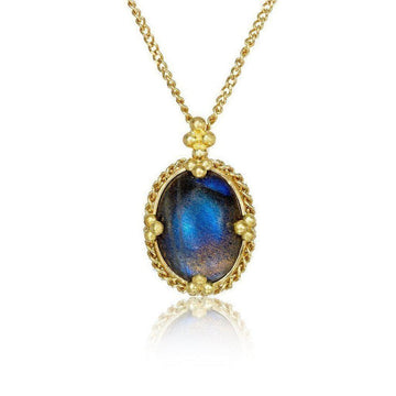 Oval moonstone pendant necklace with gold chain and ornate setting.
