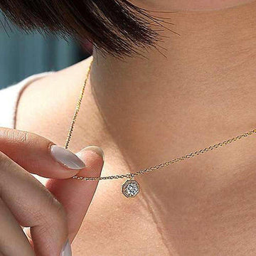 Gold chain necklace with octagonal diamond pendant.
