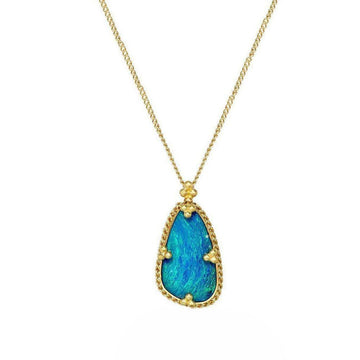 Teardrop opal pendant necklace with gold chain and ornate setting.
