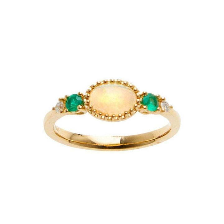 Gold opal and emerald ring with delicate detailing.
