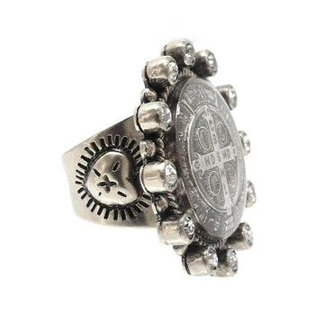Silver ring featuring a detailed medallion and clear stones.
