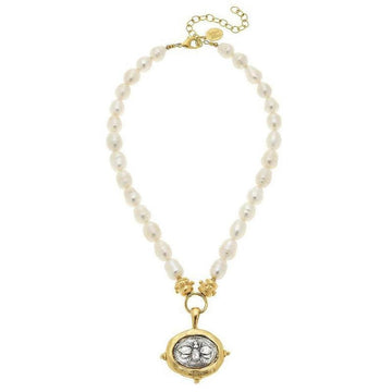 Elegant pearl necklace with gold-framed bee pendant.
