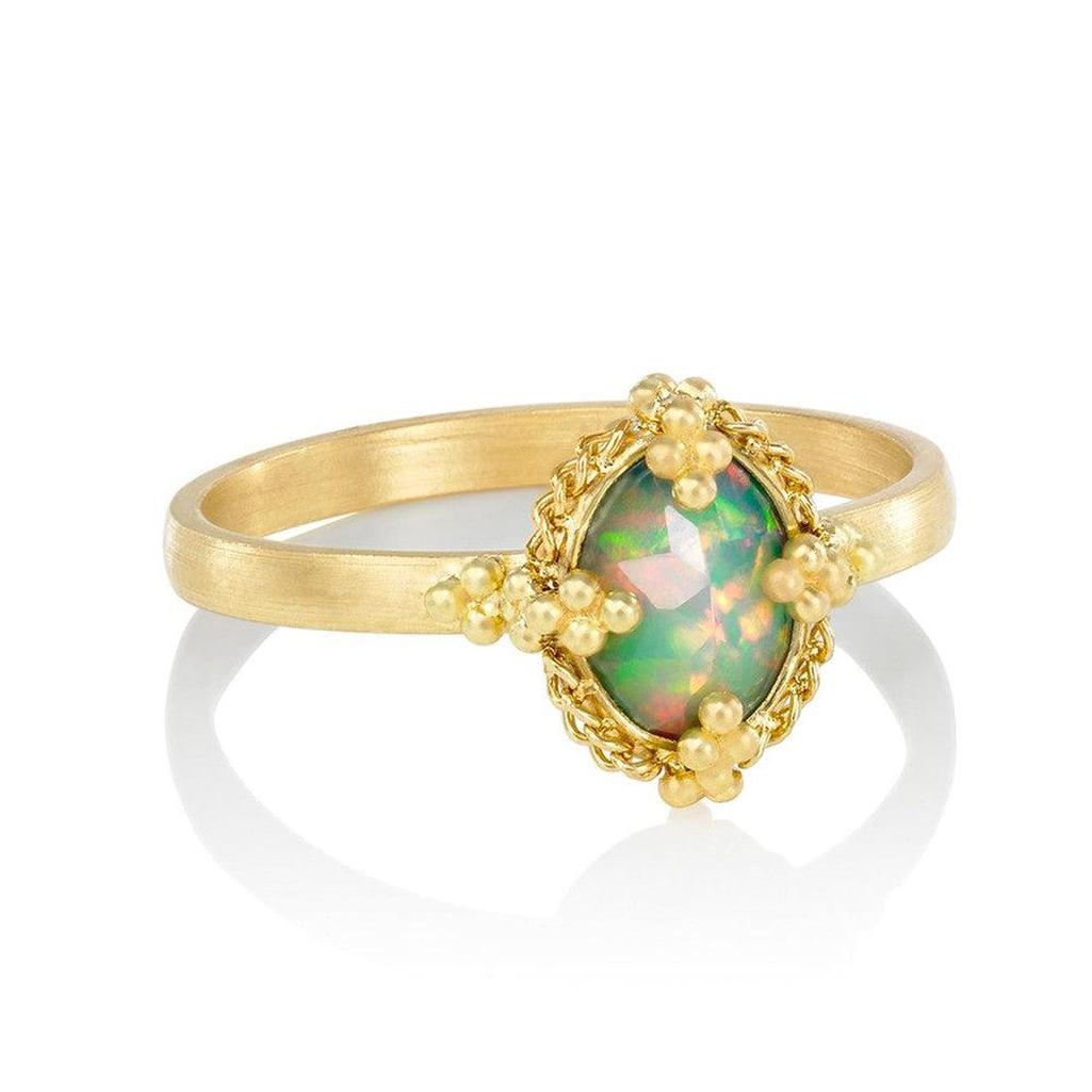Oval Prong Black Opal ring in 18k gold with ornate detailing.
