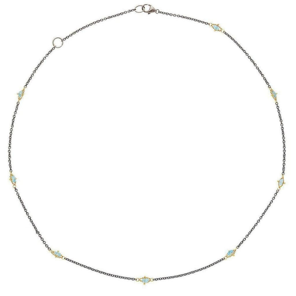 Oxidized silver necklace with 18k gold accents and blue topaz gemstones.
