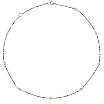 Oxidized silver necklace with 18k gold accents and blue topaz gemstones.
