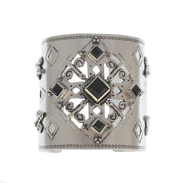 Silver cuff bracelet with ornate black stone accents and cutout detailing.
