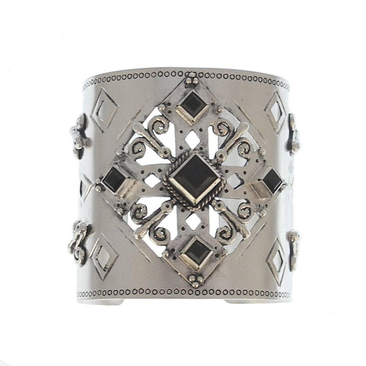 Silver cuff bracelet with ornate black stone accents and cutout detailing.
