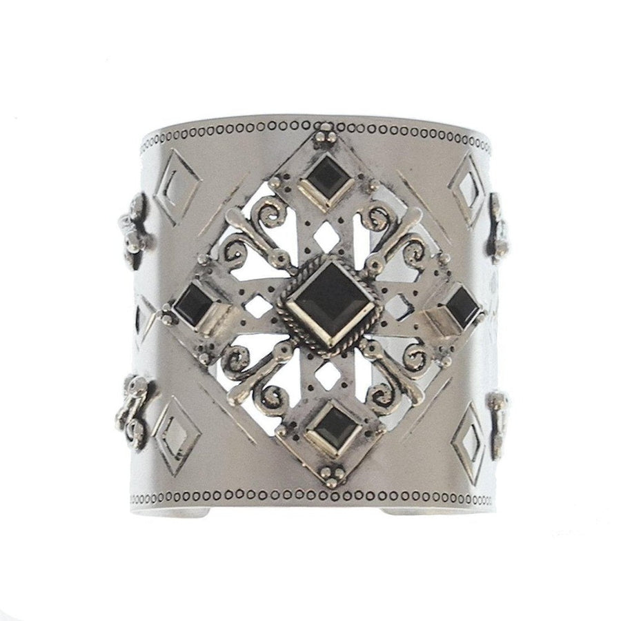 Silver cuff bracelet with ornate black stone accents and cutout detailing.
