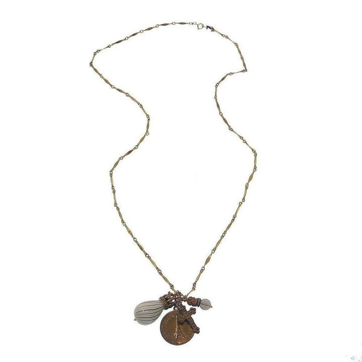 Gold chain necklace featuring a Paris medallion, cross charm, and glass bead accents.
