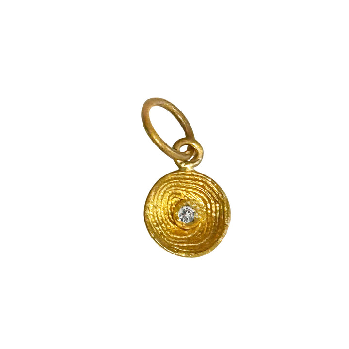 Small 24k gold sundial pendant featuring a textured circular design and a central diamond accent on a gold bale.
