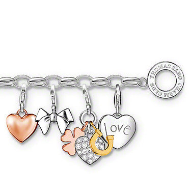 Silver charm bracelet featuring heart, bow, clover, horseshoe, and "love" charms.
