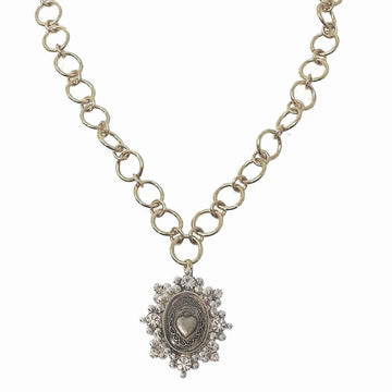 Gold chain necklace with ornate silver pendant featuring a heart and clear stones.
