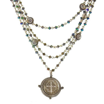 Layered metallic blue crystal necklace with a silver medallion pendant.
