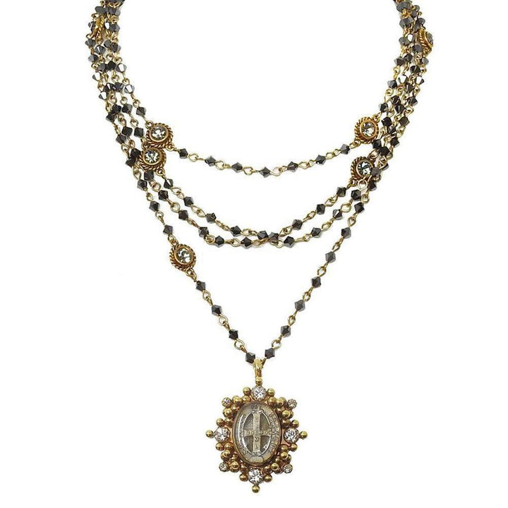 Layered gemstone necklace with antique-style pendant.
