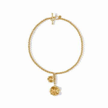 Gold lariat necklace with textured chain and floral charms.
