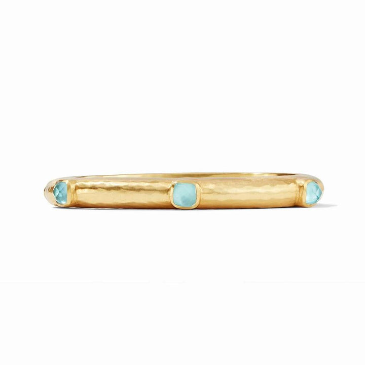 Gold hinged bangle featuring light blue gemstones.
