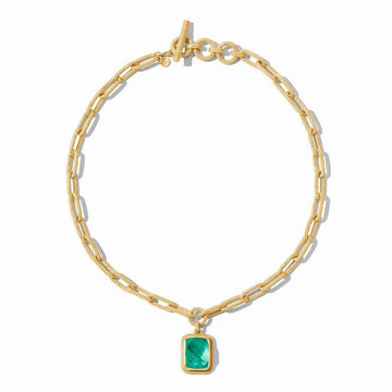 Gold chain necklace with textured links and a green gemstone pendant.
