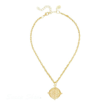 Gold compass pendant necklace with rope chain.
