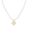 Gold cross pendant necklace on pearl strand.

