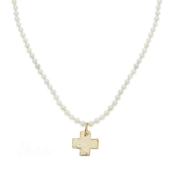 Gold cross pendant necklace on pearl strand.
