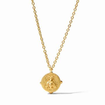 Gold bee pendant necklace with textured circular charm and delicate chain.
