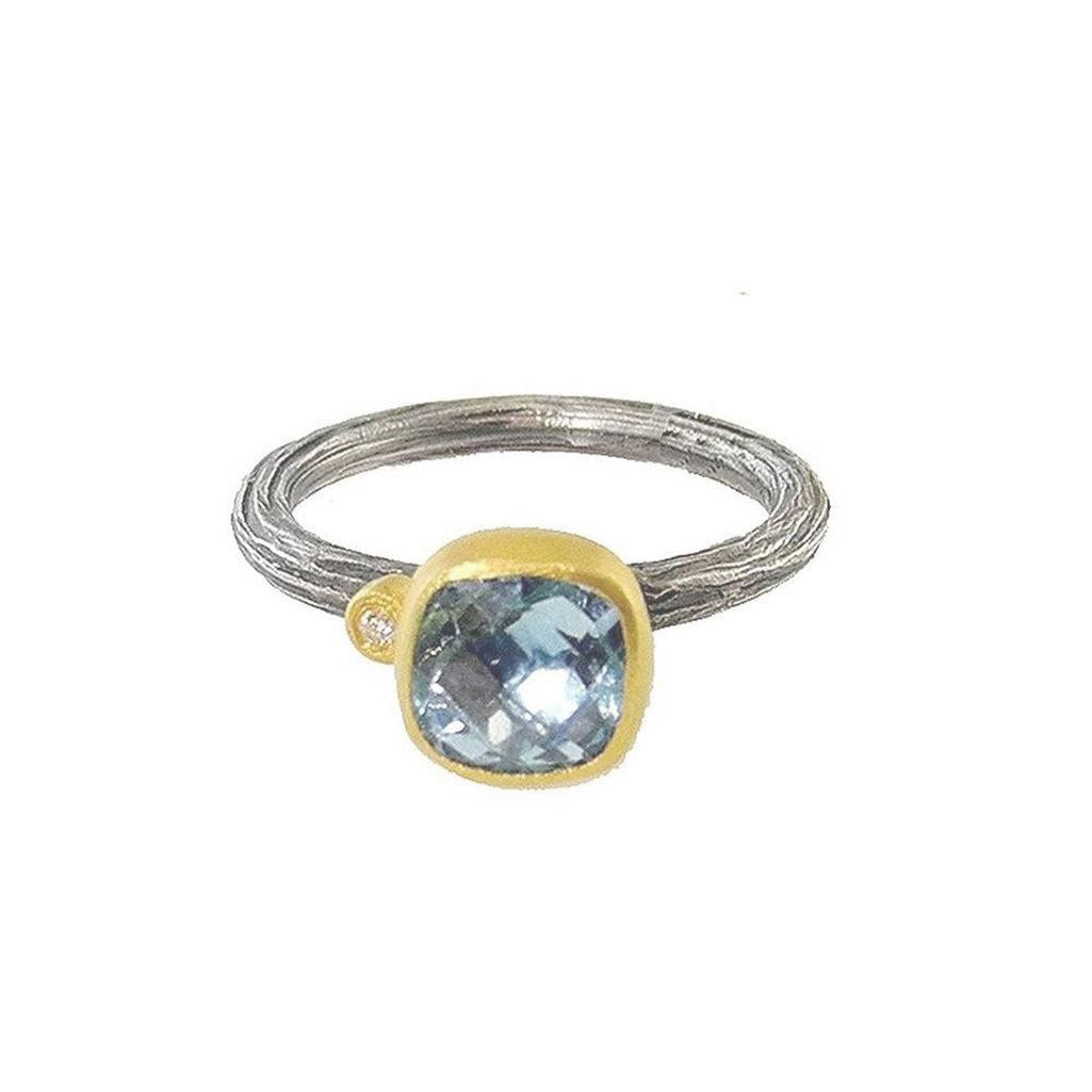 Light blue topaz ring with textured silver band and accent diamond
