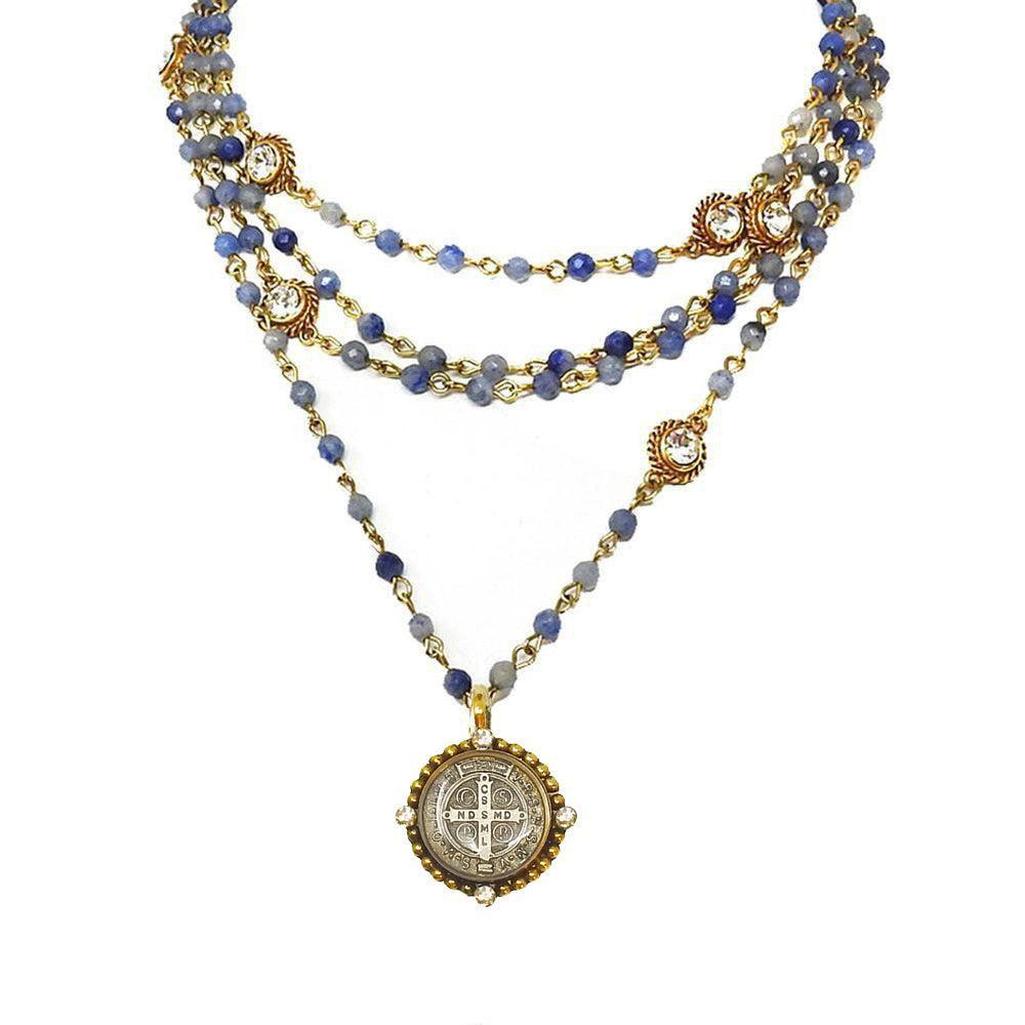 Magdalena in Gold Blue Obsidian necklace: layered blue gemstone & gold chain with ornate pendant.
