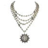 Multi-strand silver necklace with smoky quartz beads and a detailed medallion pendant.
