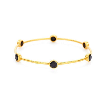 Gold bangle bracelet adorned with six black stones.
