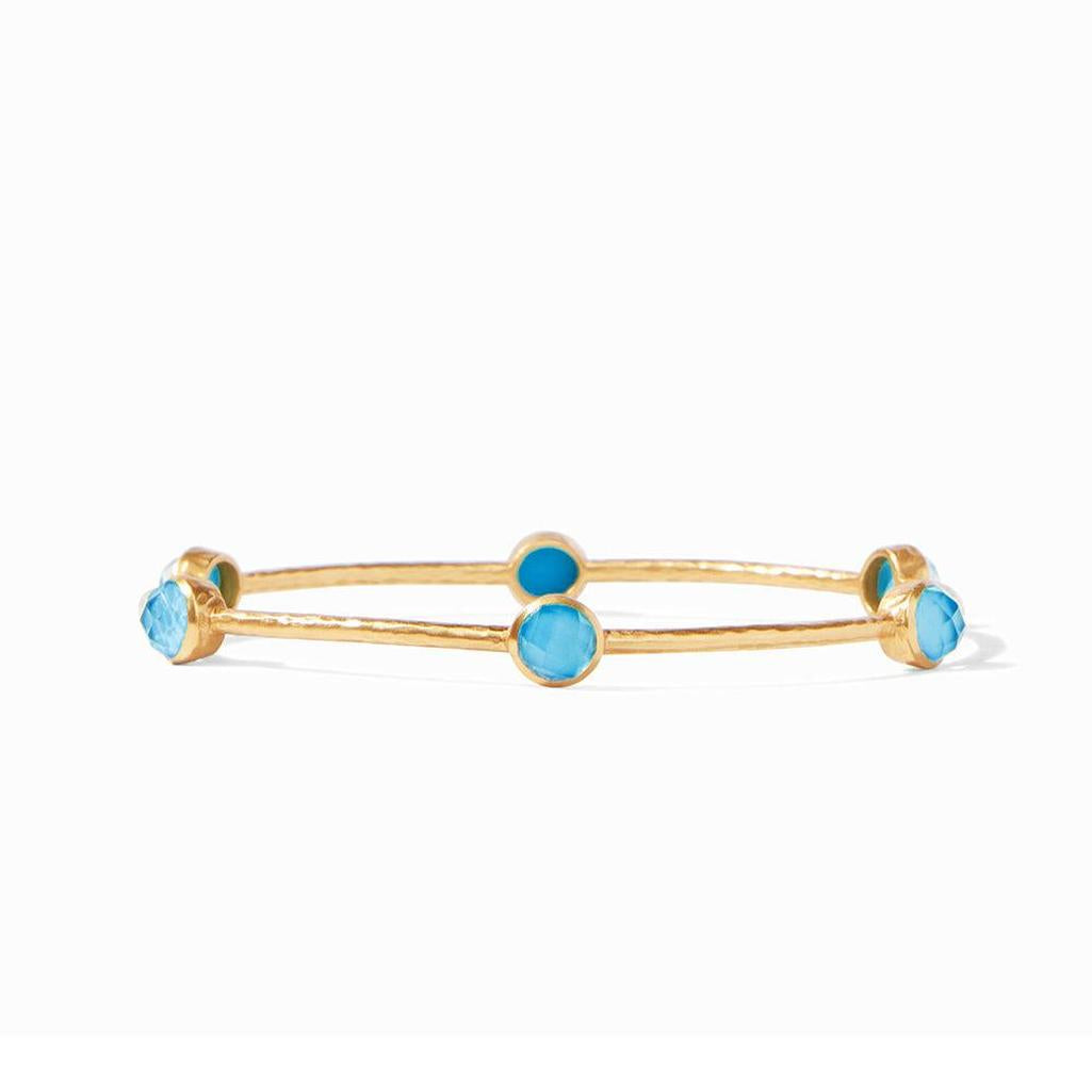 Gold bangle bracelet adorned with five light blue stones.
