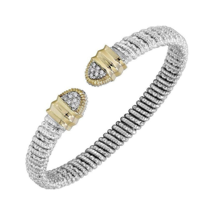 Open bracelet with diamond tips; silver and gold textured design.
