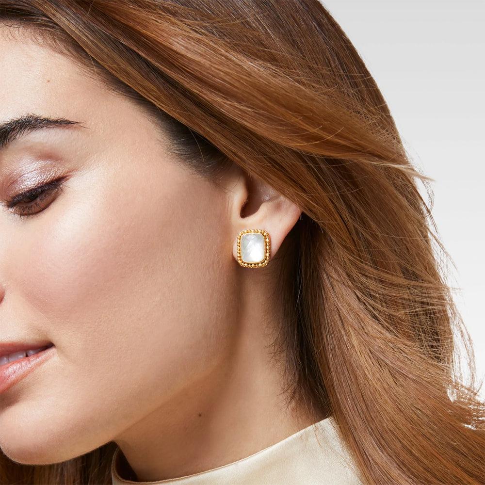 Gold stud earrings featuring a white, square-shaped stone.
